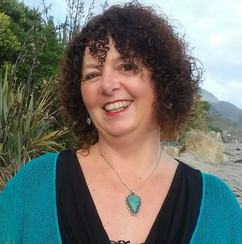 Vicki Lawson smiling on the beach, wearing a turquoise pendant